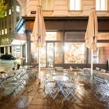 Wien, Österreich. Leere Tische und Stühle stehen vor einem Restaurant.