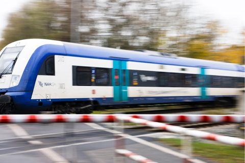 Ein Regionalexpress fährt an einem Bahnübergang vorbei.