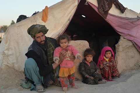 Farishteh (r.) und Shokriya (2 v. l.) mit ihrem Vater vor ihrem Zelt im Flüchtlingscamp