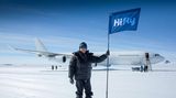 Wie einst ein Polarforscher am Südpol: Flugkapitän Carlos Mirpuri mit einem Wimpel der Charterfluggesellschaft am Ziel im Queen Maud Land.