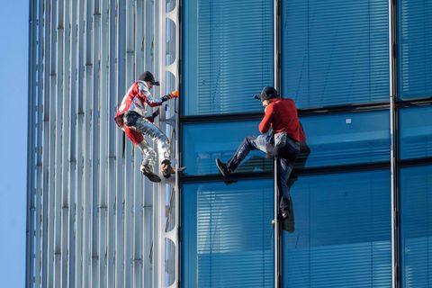 Alain Robert (l.), der französische Spiderman, trug beim Klettern Cowboystiefel und einen silberfarbenen Anzug