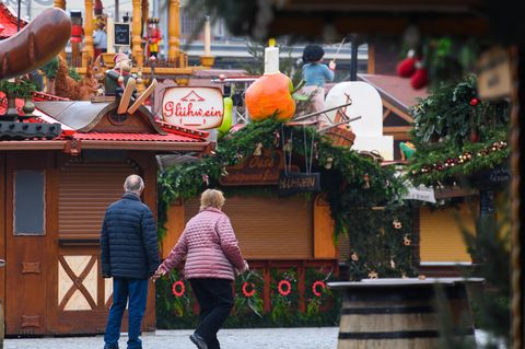 Passanten gehen an geschlossenen Verkaufsständen des Dresdner Striezelmarktes auf dem Altmarkt vorbei