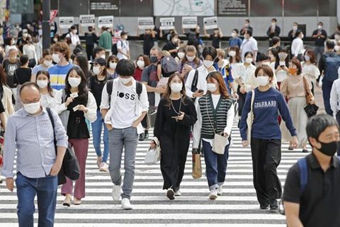 Menschen mit Maske gehen in Japan über Straße