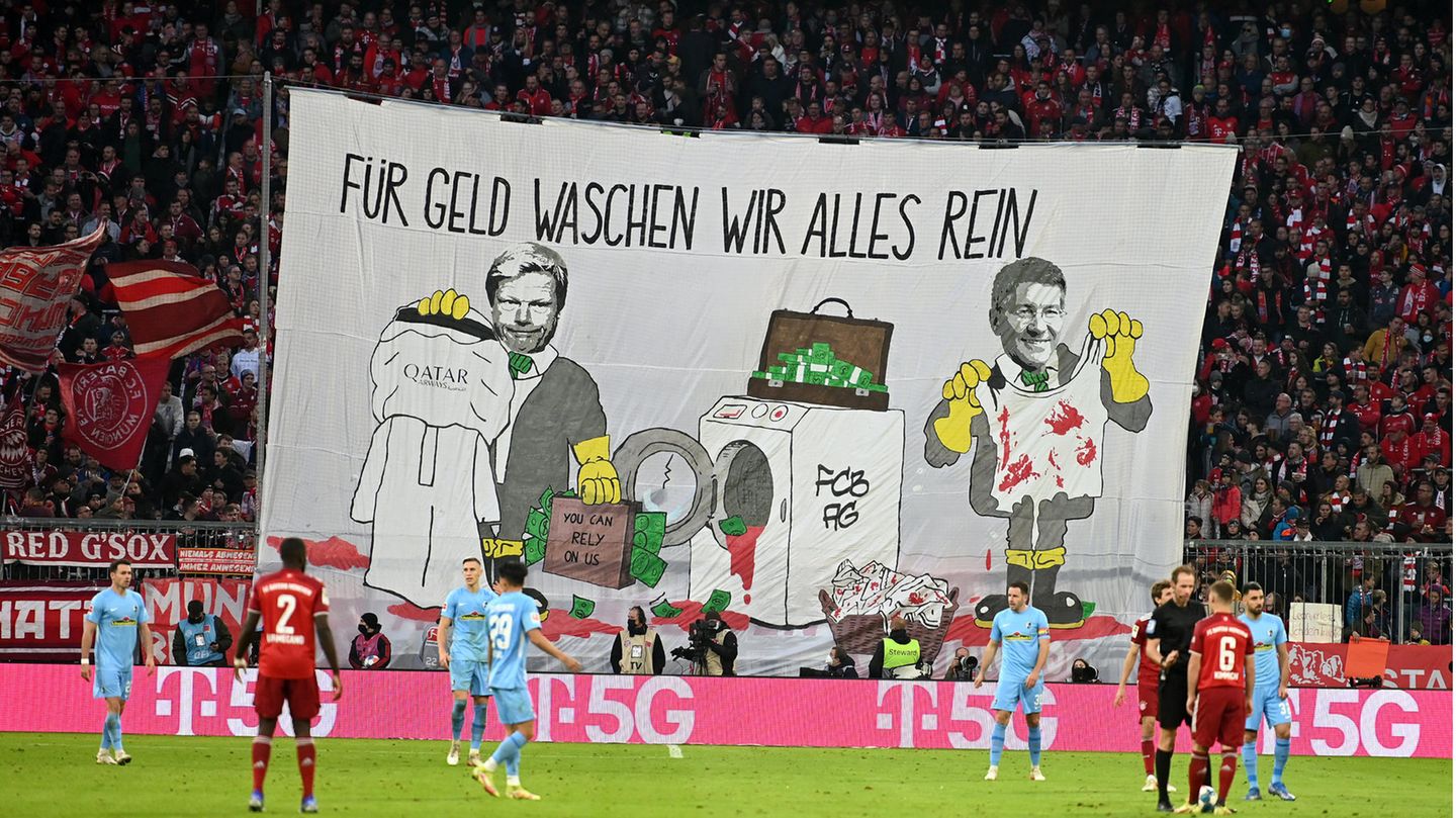 Ein Plakat mit der Aufschrift "Für Geld waschen wir alles rein" sind Oliver Kahn und Herbert Hainer zu sehen