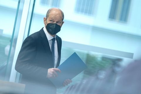 Olaf Scholz mit Maske und hinter Glas