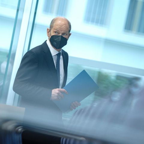 Olaf Scholz mit Maske und hinter Glas