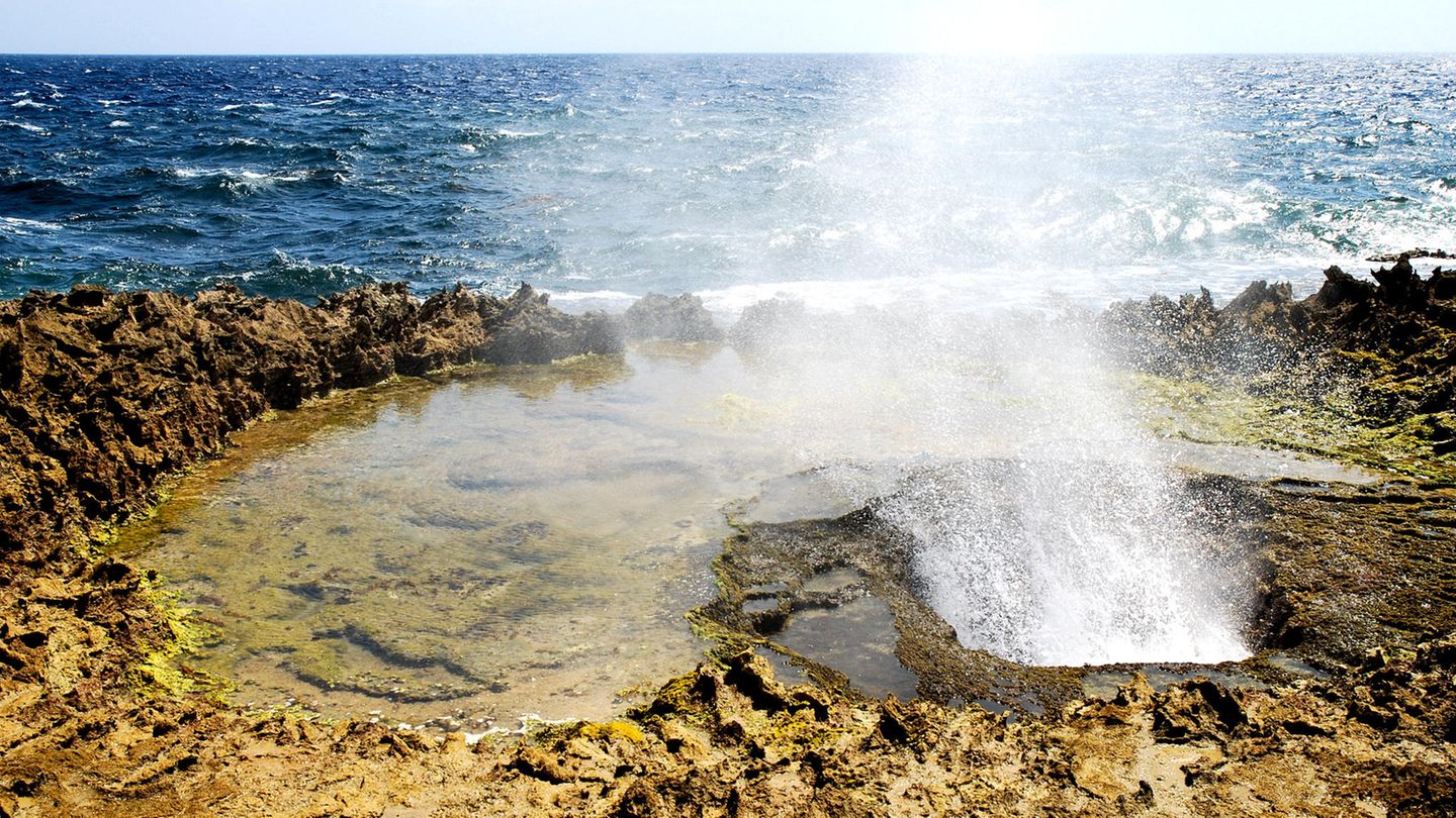Eine heiße Quelle am felsigen Strand eines Ozeans