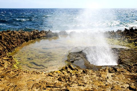 Eine heiße Quelle am felsigen Strand eines Ozeans