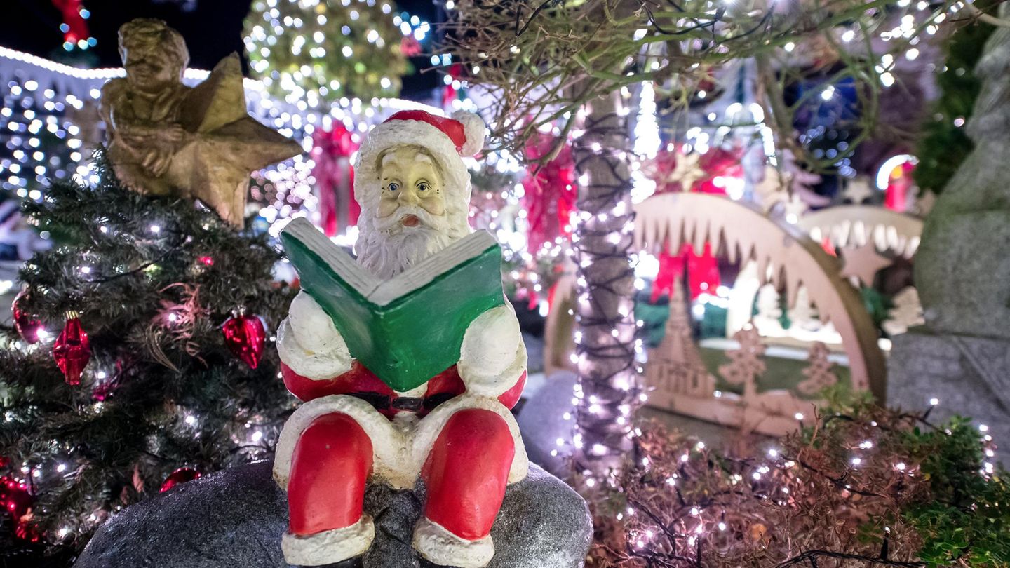 Ein Deko-Weihnachtsmann sitzt an einem weihnachtlich geschmückten Haus im niedersächsischen Delmenhorst