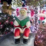 Ein Deko-Weihnachtsmann sitzt an einem weihnachtlich geschmückten Haus im niedersächsischen Delmenhorst