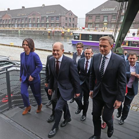 Die Verhandler des Koalitionsvertrages gehen über eine Treppe zu der Vorstellung.