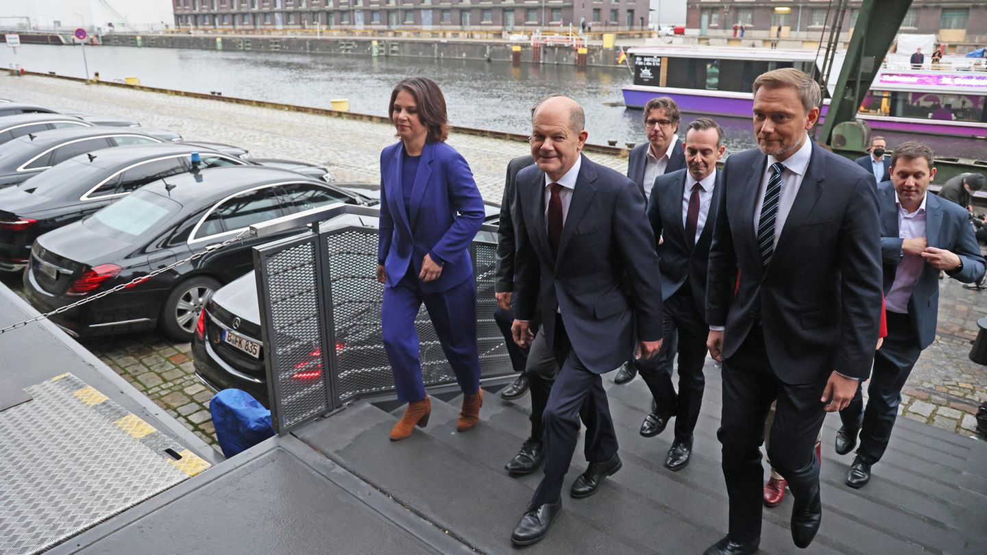 Die Ampel-Koalitionäre gehen voran Die Verhandler des Koalitionsvertrages gehen über eine Treppe zu der Vorstellung.