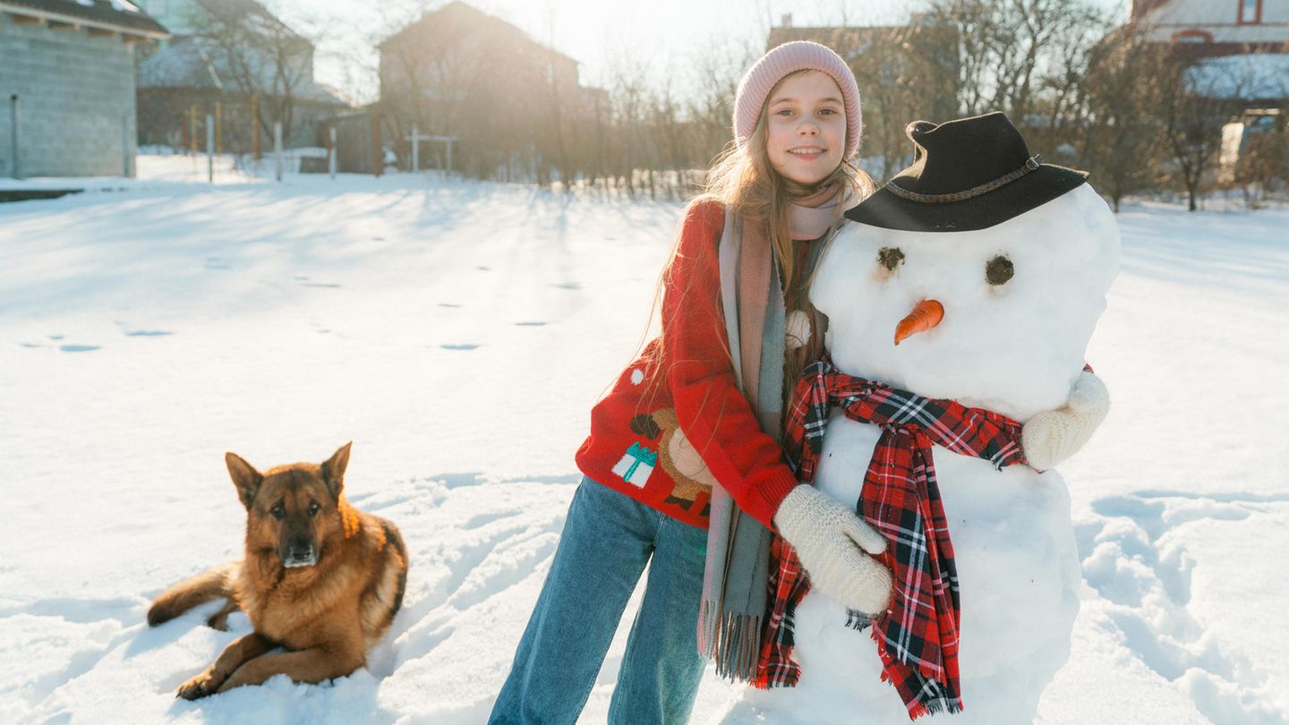 Ein Mädchen baut einen Schneemann