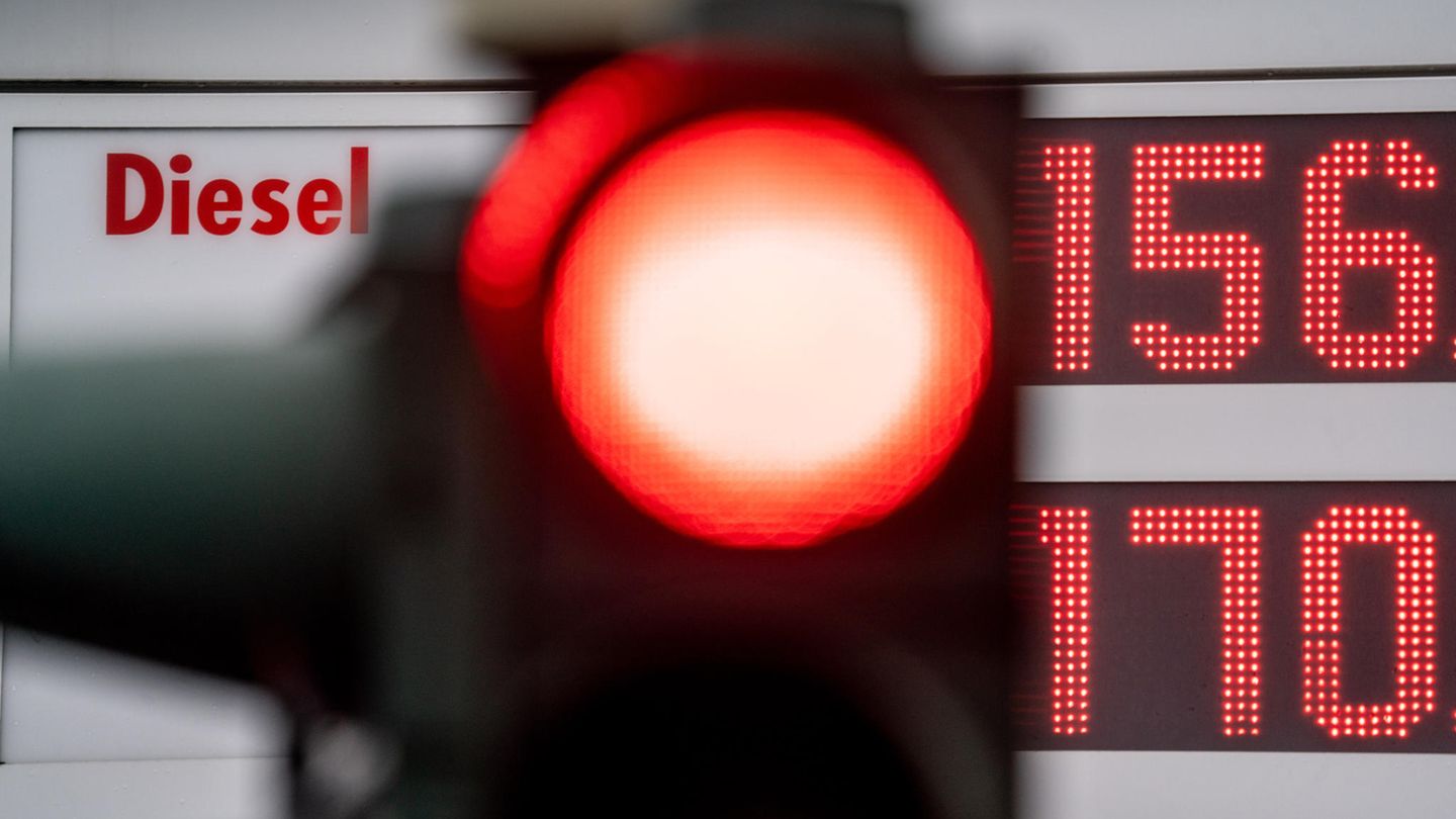 Eine rote Ampel leuchtet vor der Preistafel einer Tankstelle