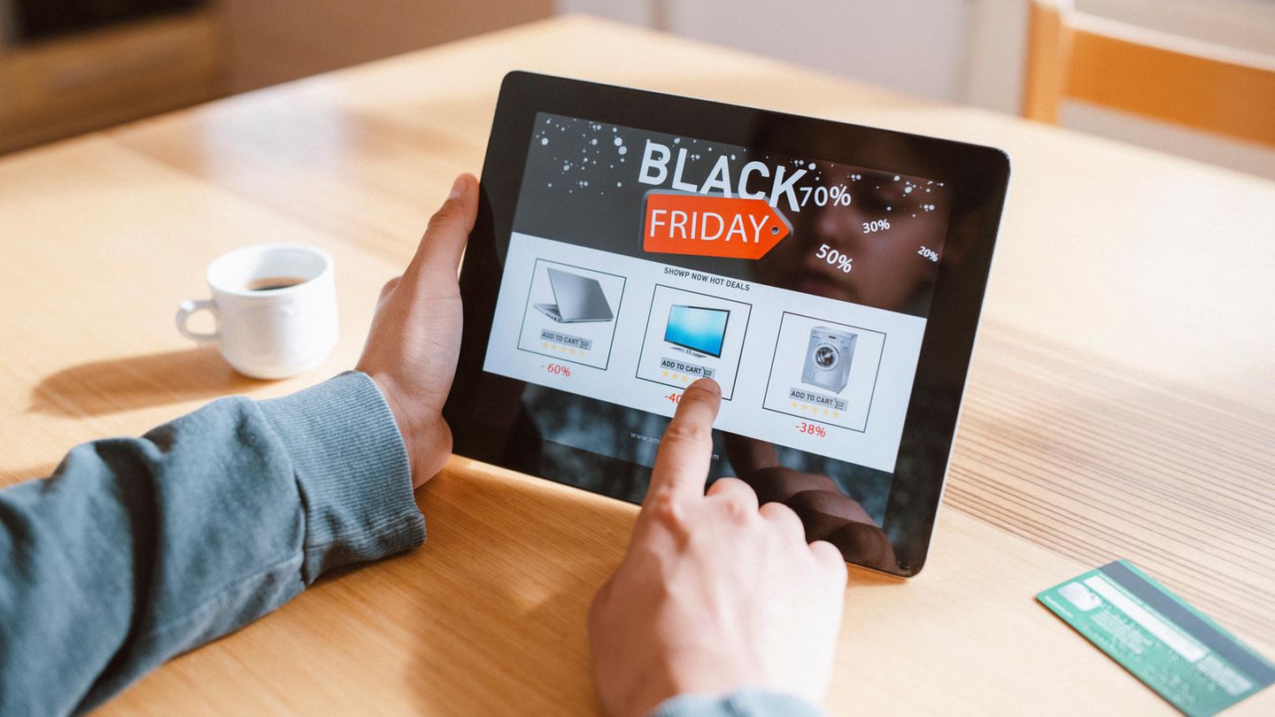 Black Friday bei Ebay: Ein Mann hält ein Tablet in der Hand.