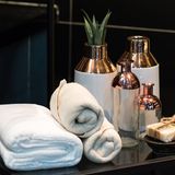 Handtücher brauchen Platz, klar. Entweder Sie rollen diese auf und stapeln die Rollen in einem offenen Regal. Oder Sie schichten die zusammengefalteten Handtücher zu einem kleinen Turm. Wichtig: Keine uralten Handtücher mit fiesen Mustern nehmen. In geschmackvolle, farblich abgestimmte Textilien zu investieren, lohnt sich!