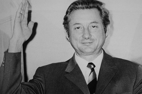 Theo Albrecht auf einem Schwarzweiß-Foto. Er winkt