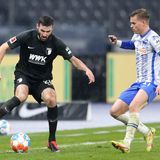Im Berliner Olympiastadion nutzte der ehemalige Augsburger Marco Richter (40.) einen Patzer seines früheren Mitspielers Robert Gumny und schoss zum 1:0 ein. Die Augsburger mussten kurzfristig auf ihren Kapitän und Innenverteidiger Jeffrey Gouweleeuw verzichten. Der 30 Jahre alte Niederländer sei unmittelbar nach Bekanntwerden eines Corona-Falls im direkten familiären Umfeld "als Vorsichtsmaßnahme von der Mannschaft isoliert worden", wie die Augsburger mitteilten. Michael Gregoritsch belohnte den Kampf der Gäste mit dem Treffer zum 1:1 in der siebten Minute der Nachspielzeit. Hier sind Augsburgs Daniel Caligiuri und Maximilian Mittelstaedt im Zweikampf.