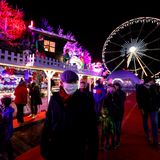 Belgien, Brüssel: Menschen tragen während eines Besuchs des Winterwunders und des Weihnachtsmarkts eine Mund-Nasen-Bedeckung