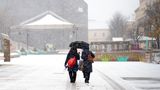 Spaziergänger im Schneefall im MQ in Wien, Österreich