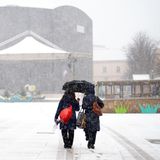 Spaziergänger im Schneefall im MQ in Wien, Österreich