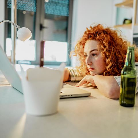 Frau arbeitet allein vor dem Laptop