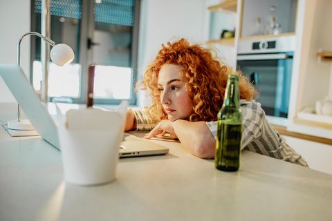 Frau arbeitet allein vor dem Laptop