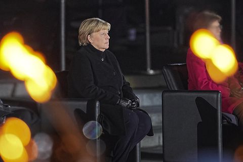 Bundeskanzlerin Angela Merkel (CDU, l.) sitzt bei ihrer Verabschiedung durch die Bundeswehr