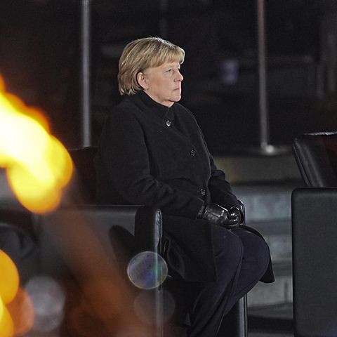 Bundeskanzlerin Angela Merkel (CDU, l.) sitzt bei ihrer Verabschiedung durch die Bundeswehr