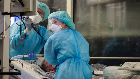 Ein Facharzt und eine Intensivpflegerin behandeln einen intubierten Covid-19-Patienten