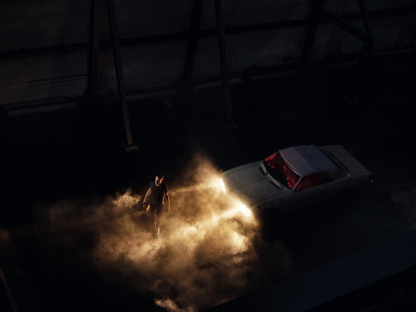 Im zwölften Monat präsentiert sich der Meister selbst: Fotograf Bryan Adams läuft im Scheinwerferlicht eines Autos durch den nächtlichen Nebel.