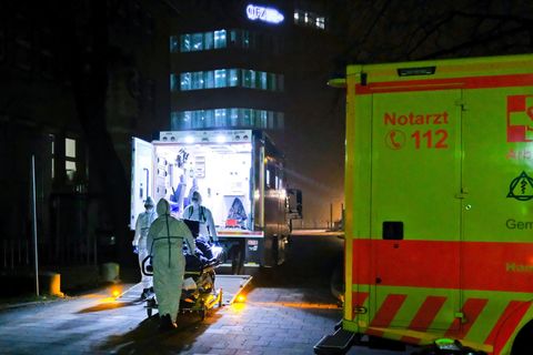 Auf einer Trage schieben Sanitäter einen Corona-Patienten in die Uniklinik Kiel. Kurz zuvor ist er aus Bayern eingeflogen worden
