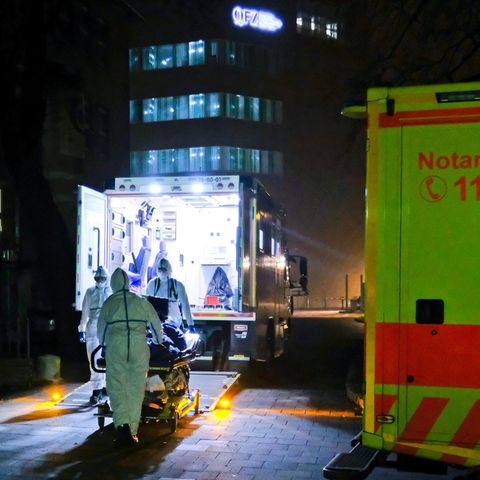 Auf einer Trage schieben Sanitäter einen Corona-Patienten in die Uniklinik Kiel. Kurz zuvor ist er aus Bayern eingeflogen worden