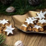 Zimtsterne      Zutaten: ca. 250 g gemahlene Mandelkerne plus etwas für die Arbeitsfläche, 2 TL Zimtpulver, 250 g Puderzucker plus etwas für die Arbeitsfläche, 3 Eiweiß, 100 g Puderzucker, 1–2 EL Zitronensaft      Zubereitung:  Die Mandeln auf die Arbeitsfläche häufen und in der Mitte eine Mulde formen. Den Zimt auf die Mandeln streuen und in die Mitte den Puderzucker und das Eiweiß geben. Von der Mitte aus zu einem Teig verkneten, der nicht mehr zu sehr an den Händen klebt. Falls nötig, noch Mandeln dazugeben.  In Frischhaltefolie gewickelt am besten über Nacht (mindestens jedoch 4 Stunden) kalt stellen. Anschließend auf der leicht mit Puderzucker oder Mandeln bestreuten Arbeitsfläche 4–5 mm dünn ausrollen. Sterne ausstechen und auf ein mit Backpapier belegtes Backblech legen. Nochmals etwa 1 Stunde kalt stellen.  Den Backofen auf 175 °C Ober-/Unterhitze vorheizen.  Die Sterne 10–15 Minuten goldbraun backen. Aus dem Ofen nehmen, mit einer Palette auf ein Kuchengitter setzen und auskühlen lassen.  Den Puderzucker mit dem Zitronensaft zu einem dickflüssigen Guss anrühren. Mit einer Spritztüte die Sterne nach Belieben verzieren.