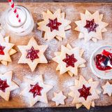 Linser Plätzchen      Zutaten:  150 g weiche Butter, 50 g Puderzucker, 1 Päckchen Vanillezucker, 1 Ei, 150 g Mehl, 150 g gemahlene Mandeln, ½ TL Backpulver, ¼ TL Zimt, 1 Prise gemahlene Nelken, 1 TL Backkakao, 150 g Johannisbeer-Gelee (oder andere Sorte), Puderzucker zum Bestäuben         Zubereitung:  Zunächst wird die Butter mit dem Puderzucker und dem Vanillezucker cremig gerührt. Danach wird das Ei untergeschlagen und nacheinander alle trockenen Zutaten dazugegeben.  Den leicht klebrigen Teig auf einer stark bemehlten Arbeitsfläche weich und geschmeidig kneten. Er sollte danach nicht mehr kleben. Anschließend für 1 Stunde kalt stellen.  Danach wird der Teig ca. 4 mm dick ausgerollt. Dabei immer wieder mit Mehl bestäuben, damit er nicht anklebt. Nun können Plätzchen ausgestochen werden, dabei immer eine Unterseite und eine Oberseite mit Öffnung ausstechen. Die Plätzchen werden im vorgeheizten Ofen bei 175 Grad Umluft maximal 8-10 Minuten gebacken und anschließend ausgekühlt.  Die Oberseite der Plätzchen wird nun dick mit Puderzucker bestäubt und die Unterseite mit dem erwärmten Johannisbeer-Gelee bestrichen. Beide Seiten können nun vorsichtig aneinander geklebt werden. Das restliche Gelee kommt in einen Spritzbeutel, damit werden nun alle Aushöhlungen zu Ende befüllt.  Die Plätzchen sind in einer luftdichten Dose mehrere Wochen haltbar und schmecken immer besser, je länger sie aufbewahrt werden.