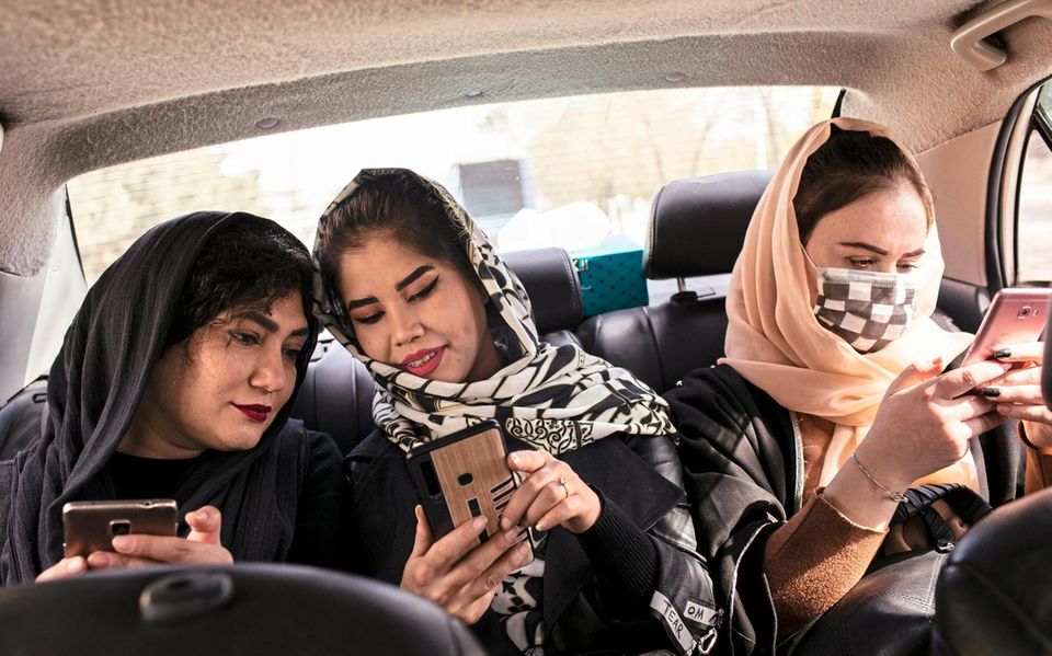 Fahrt ins Wochenende: Hamida (r.) und ihre WG-Mitbewohnerinnen unterwegs zu einer Hochzeit. Auf dem Handy liest sie Nachrichten aus ihrem Aktivistinnen-Netzwerk