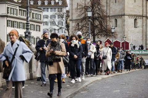 Menschen stehen in Zürich in Warteschlange