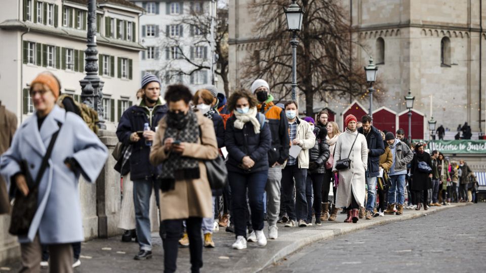 Menschen stehen in Zürich in Warteschlange