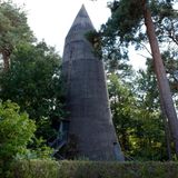 Ein Hochbunker umzingelt von Bäumen