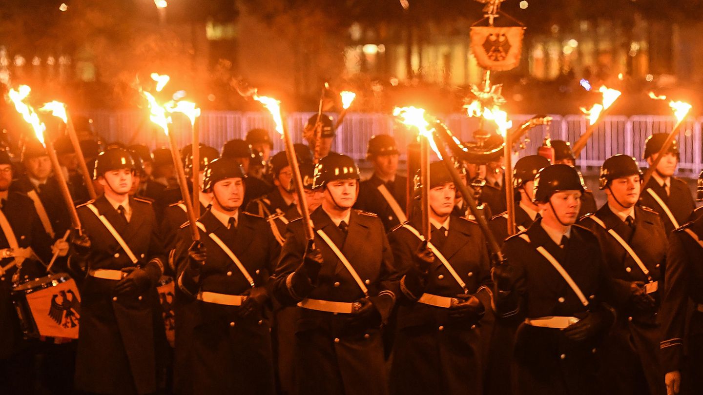 Soldaten in Uniformen stehen mit Fackeln in der Dunkelheit