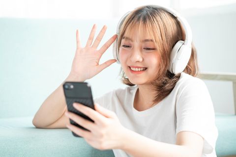 Eine junge Frau hört Musik mit ihrem Smartphone