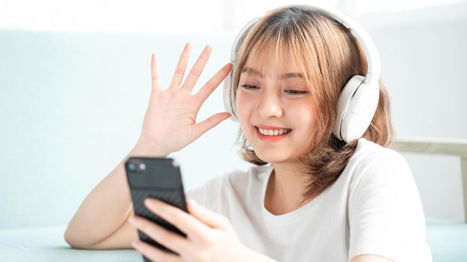 Eine junge Frau hört Musik mit ihrem Smartphone