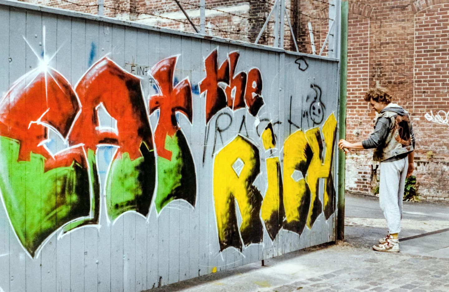 Eat the Rich - Hamburg Ottensen 1988  Die beiden Sprüher Gagarin und Gabba brachten den linken Slogan im Zuge des Protestes gegen die zunehmende Gentrifizierung des Stadtteils als bunten Schriftzug an. 