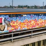 Burner auf Stahl  Der Schriftzug "Prime" weckt nicht nur farblich die Assoziation zu Feuer. Es handelt sich um einen "Burner" - ein besonders aufwendiges und qualitativ hochwertiges Bild. Das gilt sowohl für den detailreich gestalteten Schriftzug wie auch für die Figur und den Hintergrund. Dass das Werk zudem auf einer S-Bahn entstand, wertet es in der Szene noch einmal erheblich weiter auf. Das Foto erschien 1989 im stern zu einem der ersten deutschen Artikel über das Phänomen Graffiti.