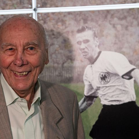 Horst Eckel im Jahr 2019 bei einer Ausstellung neben einem Bild aus seiner aktiven Zeit