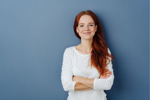 Eine junge Frau schaut selbstbewusst in die Kamera