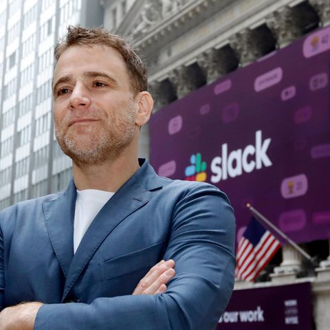 Slack-Gründer Stewart Butterfield steht vor einem Gebäude, geziert von einem großen Plakat mit dem Logo von Slack