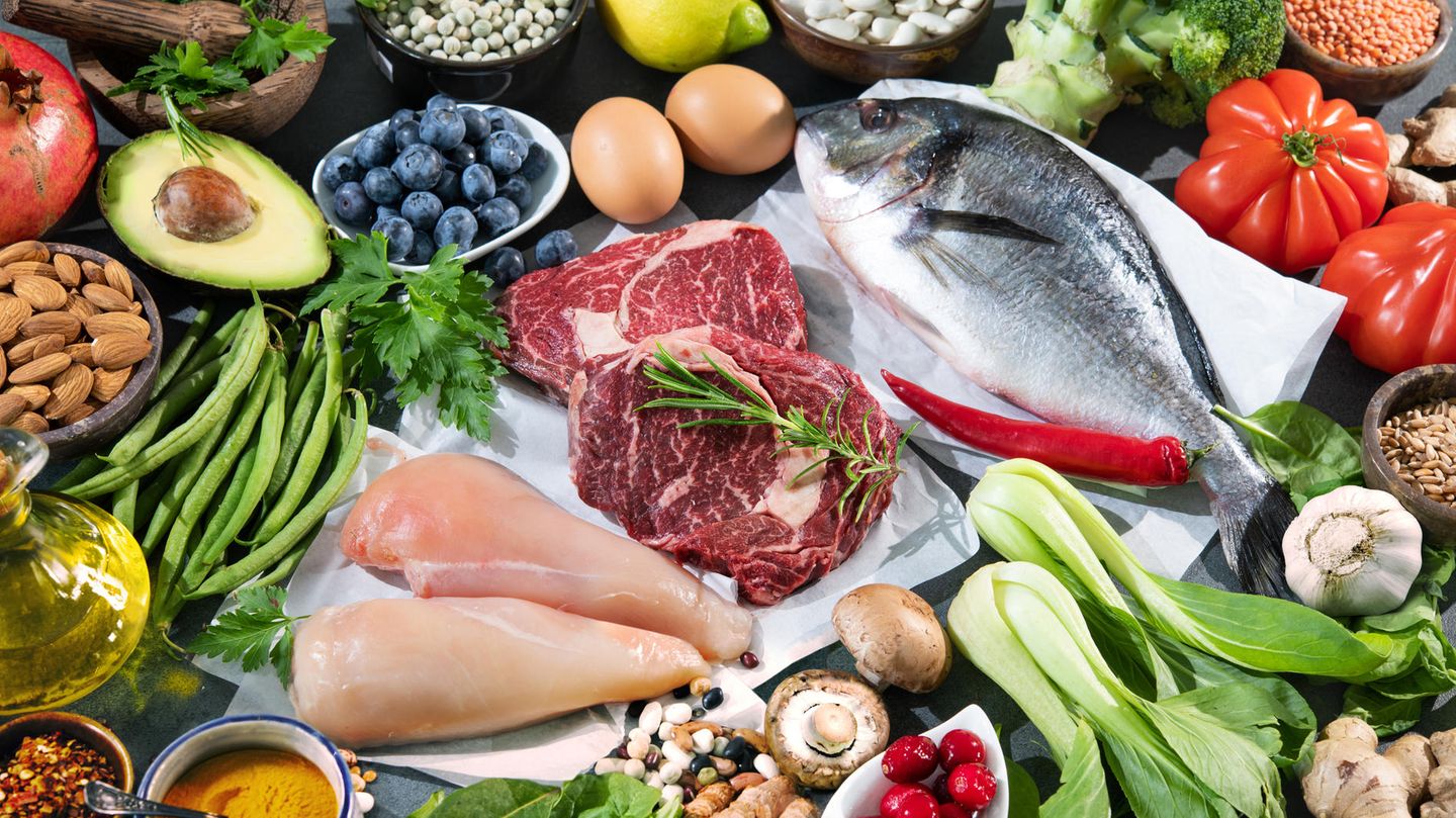 Ein Tisch voller bunter Lebensmittel: Gemüse, Fisch, Fleisch, Öle...