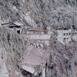 Asche hüllt die Häuser und die Landschaft auf der anderen Seite der Schlucht in ein gespenstisches Grau