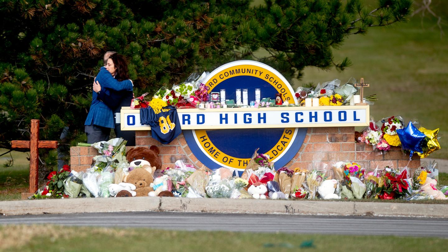 Gretchen Whitmer (r), Gouverneurin von Michigan, umarmt Dave Coulter, Oakland County Executive, als die beiden in der Oxford High School Blumen niederlegen und ihre Aufwartung machen